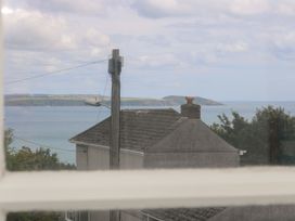 A view of the ocean and hills from a window at Driftwood Cottage in St. Austell