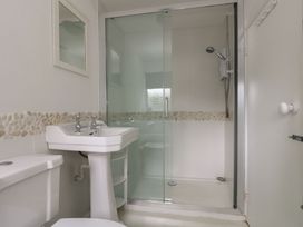 A bathroom with a shower and sink at Driftwood Cottage in St. Austell