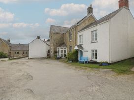 A house with a blue bench and a gravel pathway at Driftwood Cottage in St. Austell