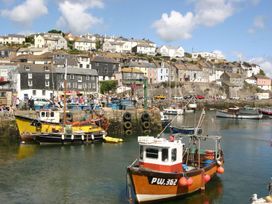 A harbor with boats and buildings at Driftwood Cottage in Porthpean