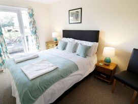 A bedroom with a bed and nightstand at Valley Lodge 2 Callington