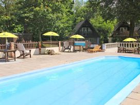 An outdoor area with a swimming pool and sun loungers at Valley Lodge 2 in Callington