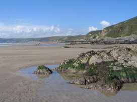 A beach with rocks and water at Valley Lodge 2 Callington