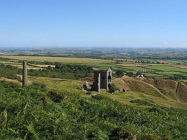 A view of ruins on a hill with fields in the background at Valley Lodge 2 in Callington