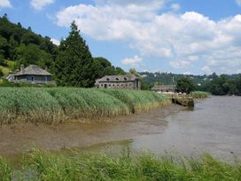 A river with buildings and grass at Valley Lodge 2 in Callington