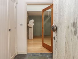 An entrance hall with a sculpture and mirror at Lower Velwell Barn in Totnes