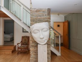 A hallway with a sculpture and staircase at Lower Velwell Barn in Totnes