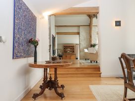 A hallway with a table and flowers at Lower Velwell Barn in Totnes