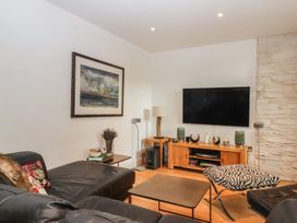 A living room with a sofa and television at Lower Velwell Barn in Totnes