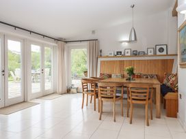 A dining room with a wooden table and chairs at Lower Velwell Barn in Totnes