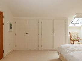 A bedroom with a bed and wardrobes at Lower Velwell Barn in Totnes