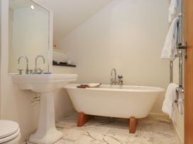 A bathroom with a bathtub and sink at Lower Velwell Barn in Totnes