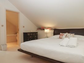 A bedroom with a bed and books on a shelf at Lower Velwell Barn in Totnes