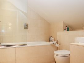 A bathroom with a bathtub, toilet, and sink at Lower Velwell Barn, Totnes