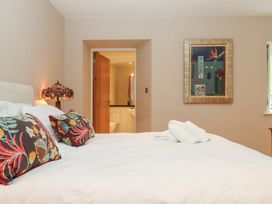 A bedroom with a bed and a view of a bathroom at Lower Velwell Barn Totnes
