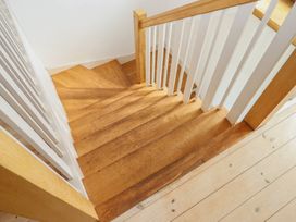 A staircase with wooden steps and a handrail at Lower Velwell Barn in Totnes