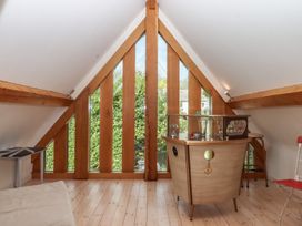 A loft with wooden beams and a bar at Lower Velwell Barn in Totnes