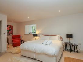A bedroom with a bed and armchair at Lower Velwell Barn Totnes