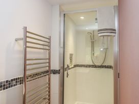 A bathroom with a shower and a towel rack at Lower Velwell Barn in Totnes