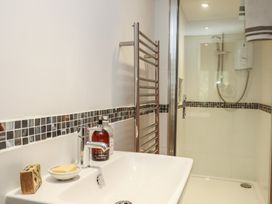 A bathroom with a sink, shower, and towel rail at Lower Velwell Barn Totnes