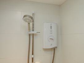 A shower with a showerhead and control unit at Lower Velwell Barn in Totnes