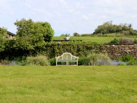 A garden with a bench and sculpture at Lower Velwell Barn in Totnes