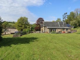 A house with solar panels and a barn in the garden at Lower Velwell Barn Totnes