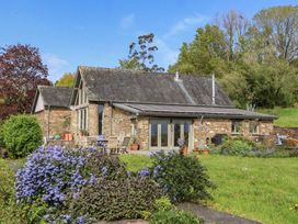 A house with outdoor seating and flowers at Lower Velwell Barn Totnes