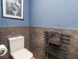 A bathroom with a toilet and towel rack at Pearl Stone House in Whitby
