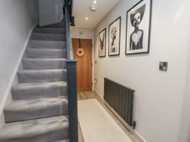 A hallway with a staircase and wall art at Pearl Stone House in Whitby