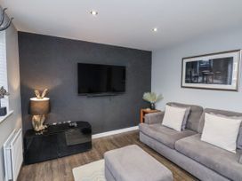 A living room with a sofa and television at Pearl Stone House in Whitby