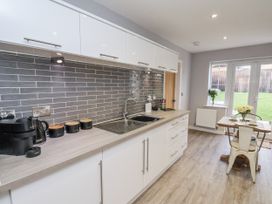 A kitchen with a countertop sink and dining area at Pearl Stone House in Whitby