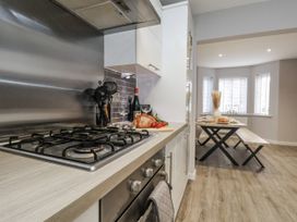 A kitchen with a gas stove and dining area at Pearl Stone House in Whitby