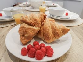 A plate with croissants and raspberries in a dining room at Pearl Stone House in Whitby