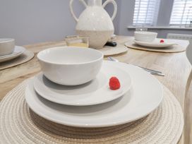 A dining table set with white plates and a pitcher at Pearl Stone House in Whitby