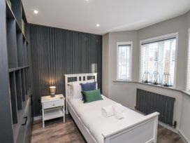 A bedroom with a single bed and nightstand at Pearl Stone House in Whitby
