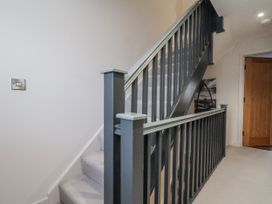A staircase with a handrail and light switch at Pearl Stone House in Whitby