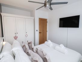 A bedroom with a bed, wardrobe and television at Pearl Stone House in Whitby
