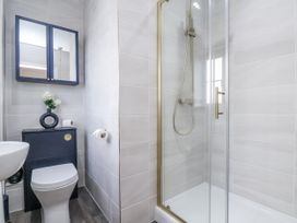 A bathroom featuring a sink, toilet, shower, and cabinet at Pearl Stone House in Whitby