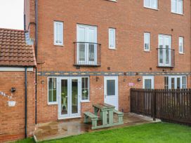 An outdoor area with a patio table and grass at Pearl Stone House in Whitby