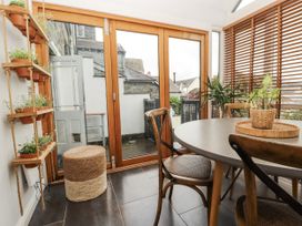 A conservatory with a round table and potted plants at 43 Station Road in Keswick