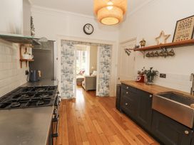 A kitchen with a gas stove and a large sink at 43 Station Road in Keswick