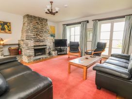 A living room with a fireplace and furniture at Tremorla in Boscastle