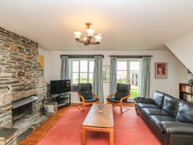 A living room with a fireplace and a tv at Tremorla in Boscastle