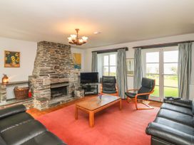 A living room with a stone fireplace and sofa at Tremorla in Boscastle