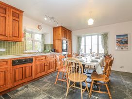A kitchen with wooden cabinets and dining table at Tremorla in Boscastle