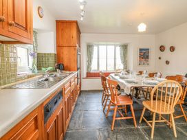A kitchen with a dining area and wooden furniture at Tremorla in Boscastle