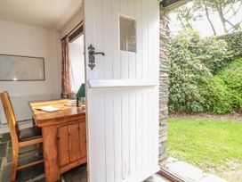 A room with a table and chairs leading to a garden at Tremorla in Boscastle