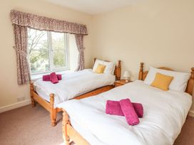 A bedroom with two single beds and a window at Tremorla in Boscastle