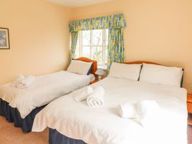 A bedroom with two beds and a window at Tremorla in Boscastle